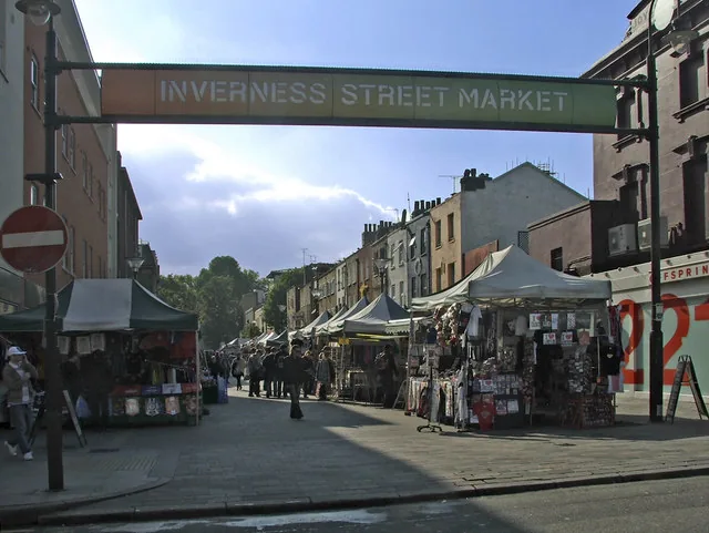 Stalls under canopies along Inverness Street beneath the Inverness Street Market sign in Camden Town