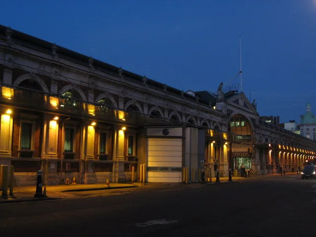 The Smithfield Market buildings lit up at dusk on West Smithfield in the City of London