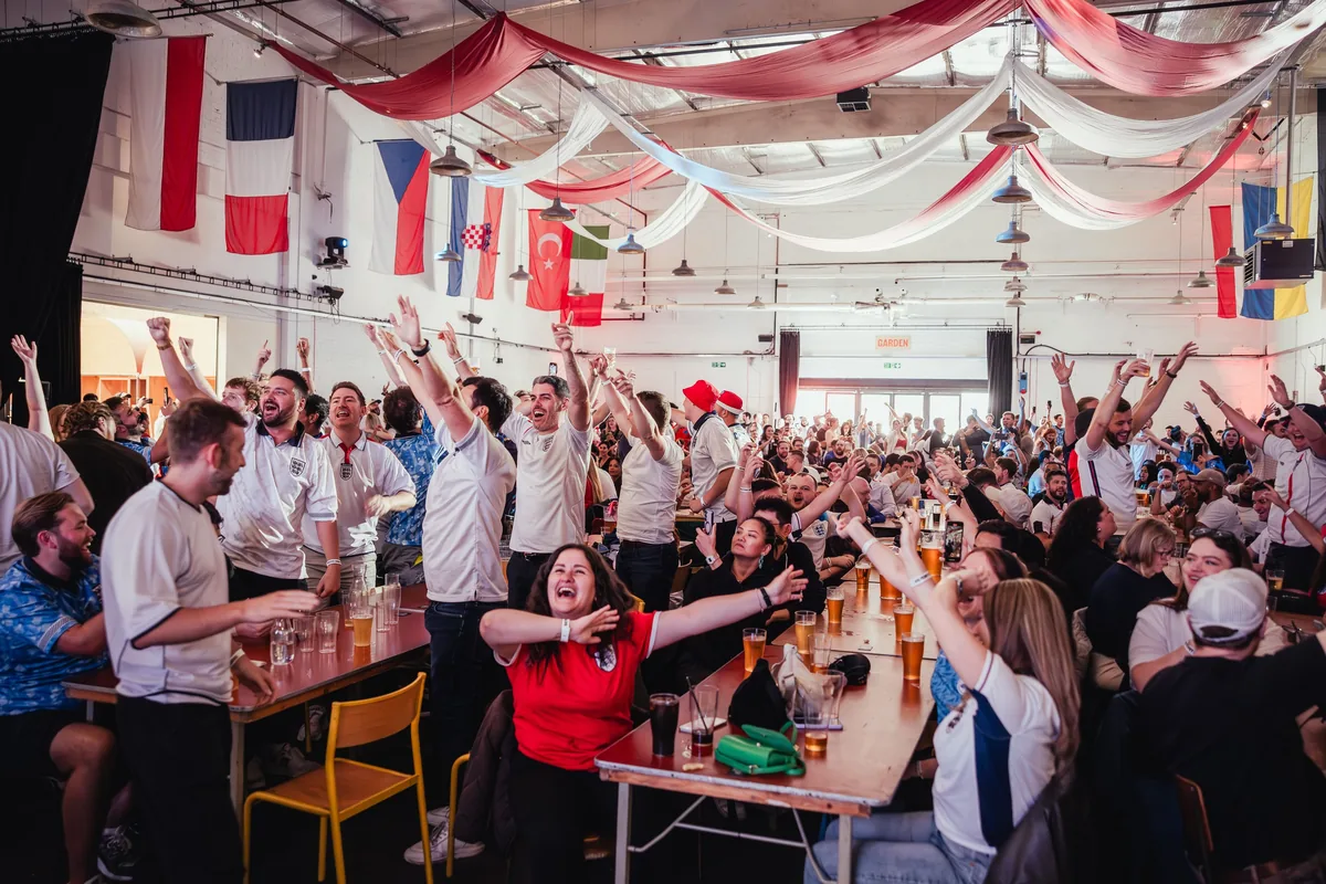 Crowd watching football on the big screen at Big Penny Social in Walthamstow